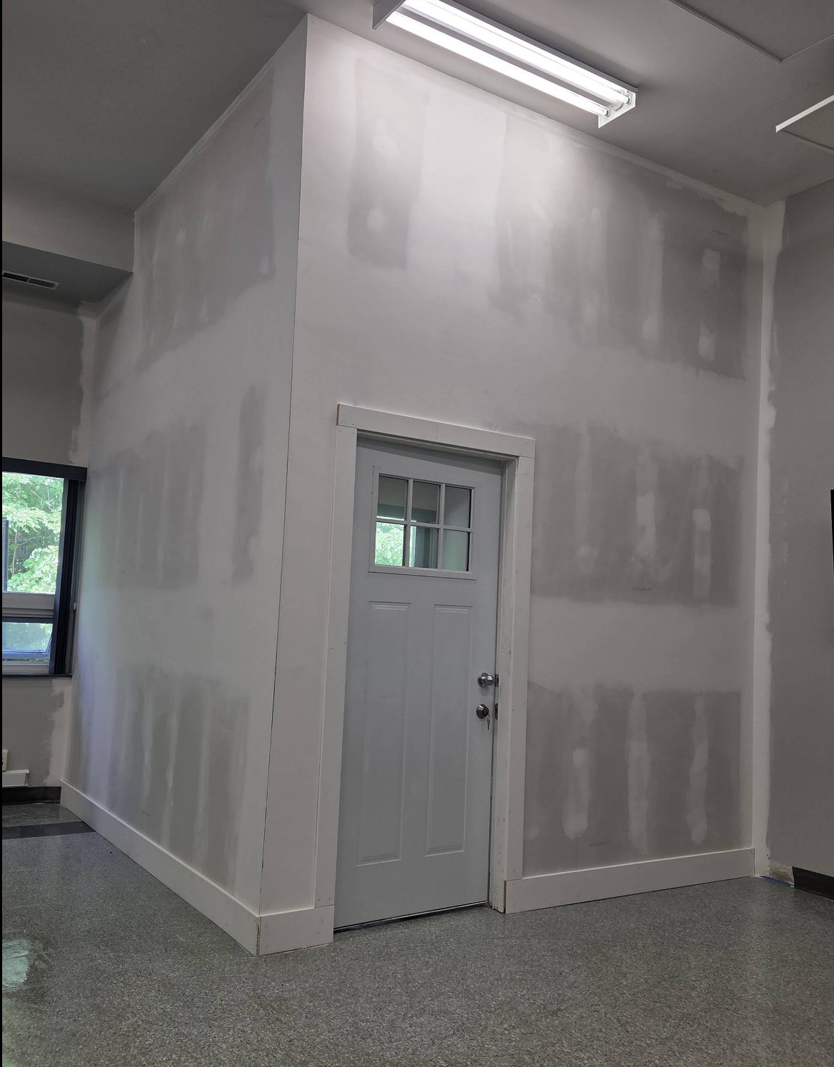 Newly framed and drywalled room with a finished door, built by Garland Contracting